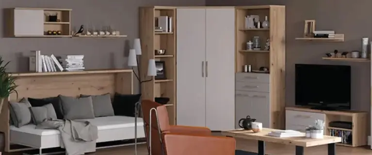 Wohnbereich mit weissem Sofa vor langer Holzrückwand und Wandregalen, davor Holztisch mit schwarzem Gestell, oranger Sessel auf dunklem Teppich, rechts Schrankwand und TV-Board.